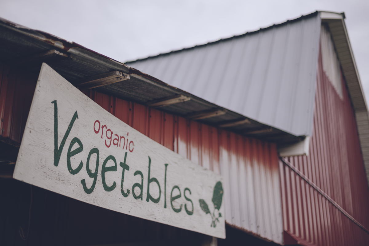 Sign on a farm stand saying "organic vegetables"