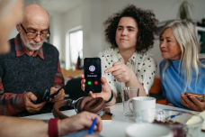 woman holding a cell phone with older man and woman on either side