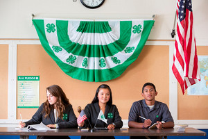 4-H professionally-dressed seniors smiling at a table