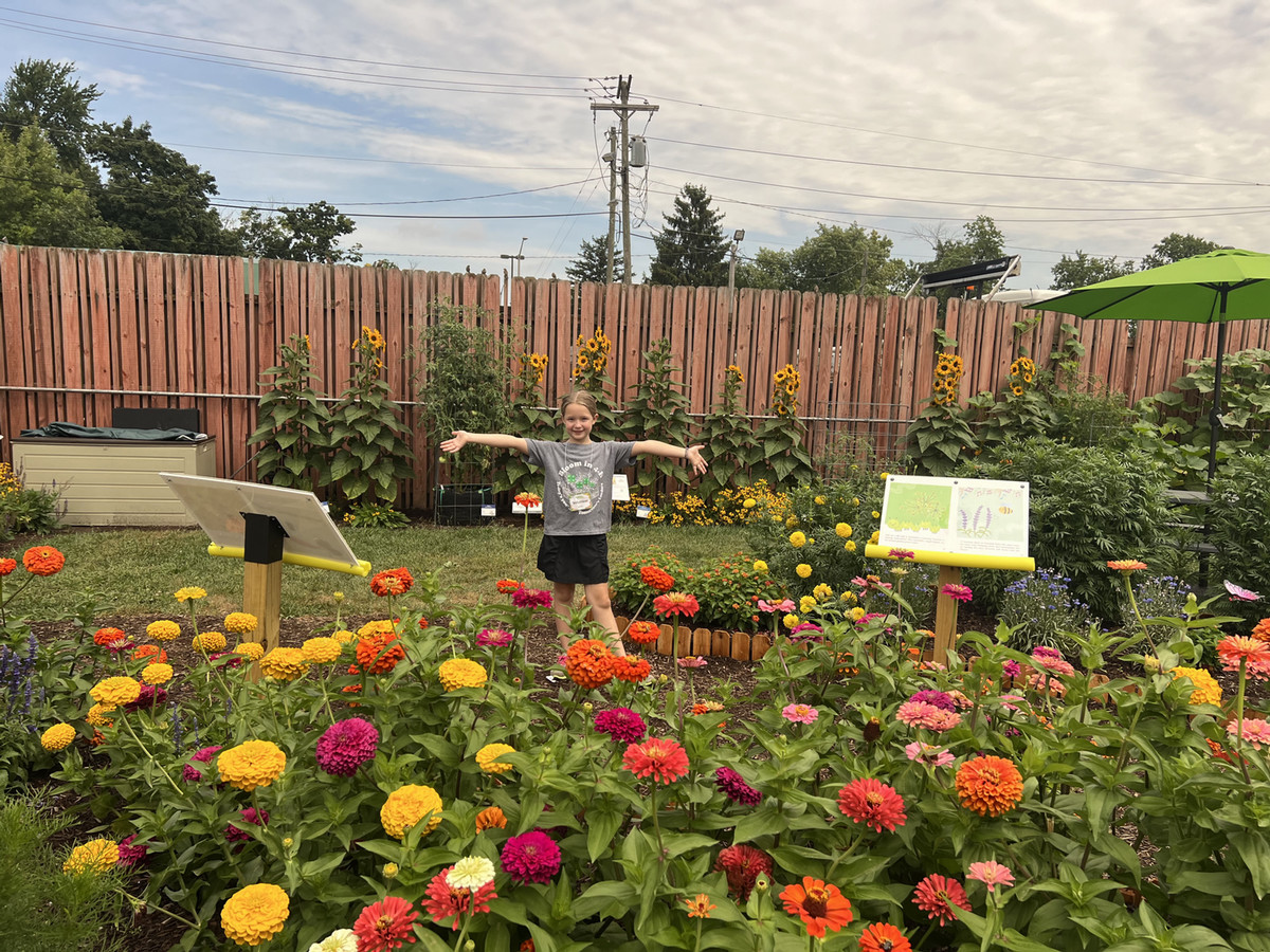 Girl standing in garden amongst flowers