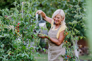 Woman watering flowers in a garden