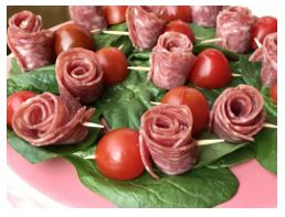 salami-rose-secured with toothpicks and cherry tomato's on spinach leaves