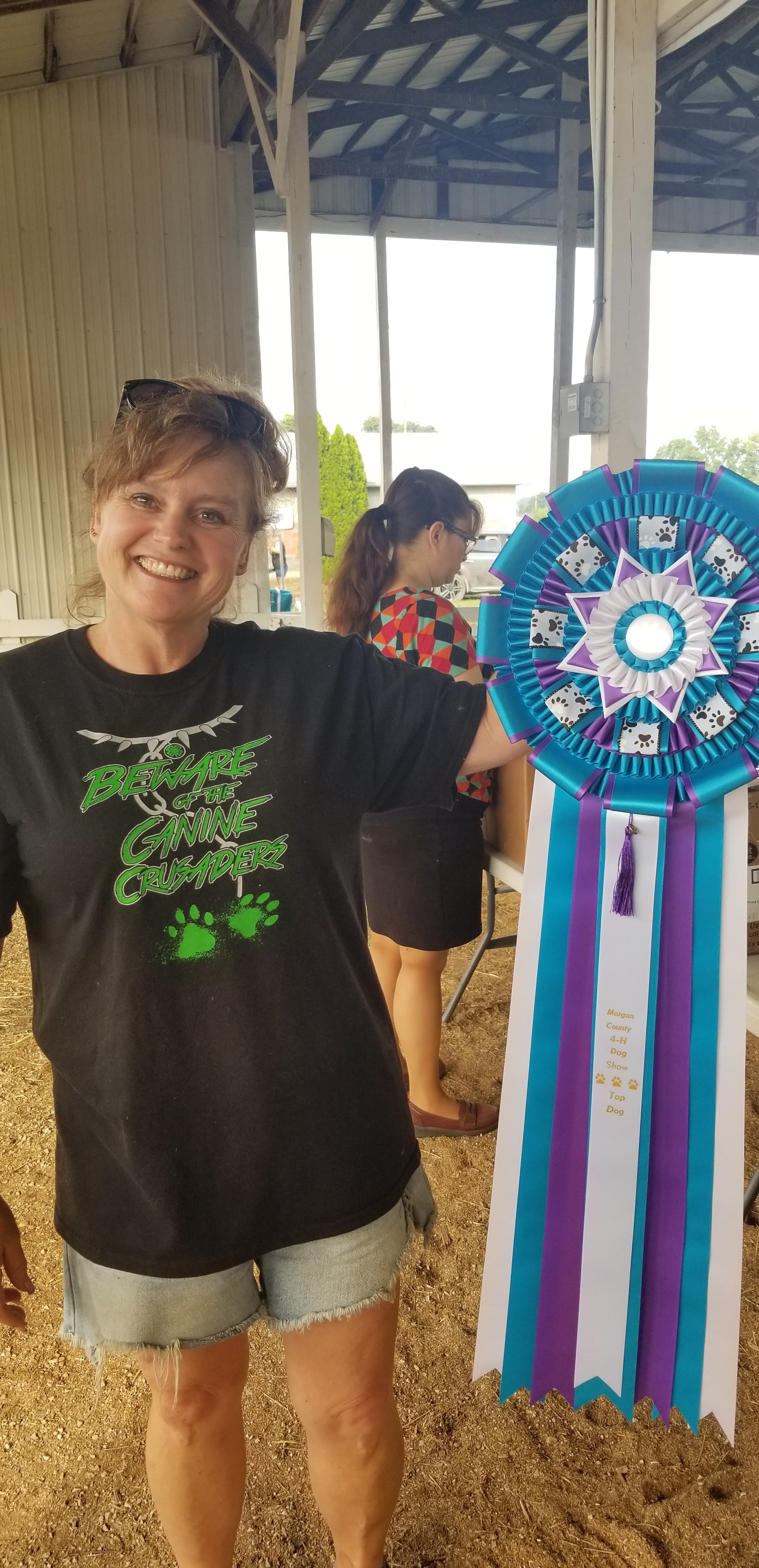 Debbie Cole 4-H Dog Club Leader with the giant champion dog ribbon for 2023
