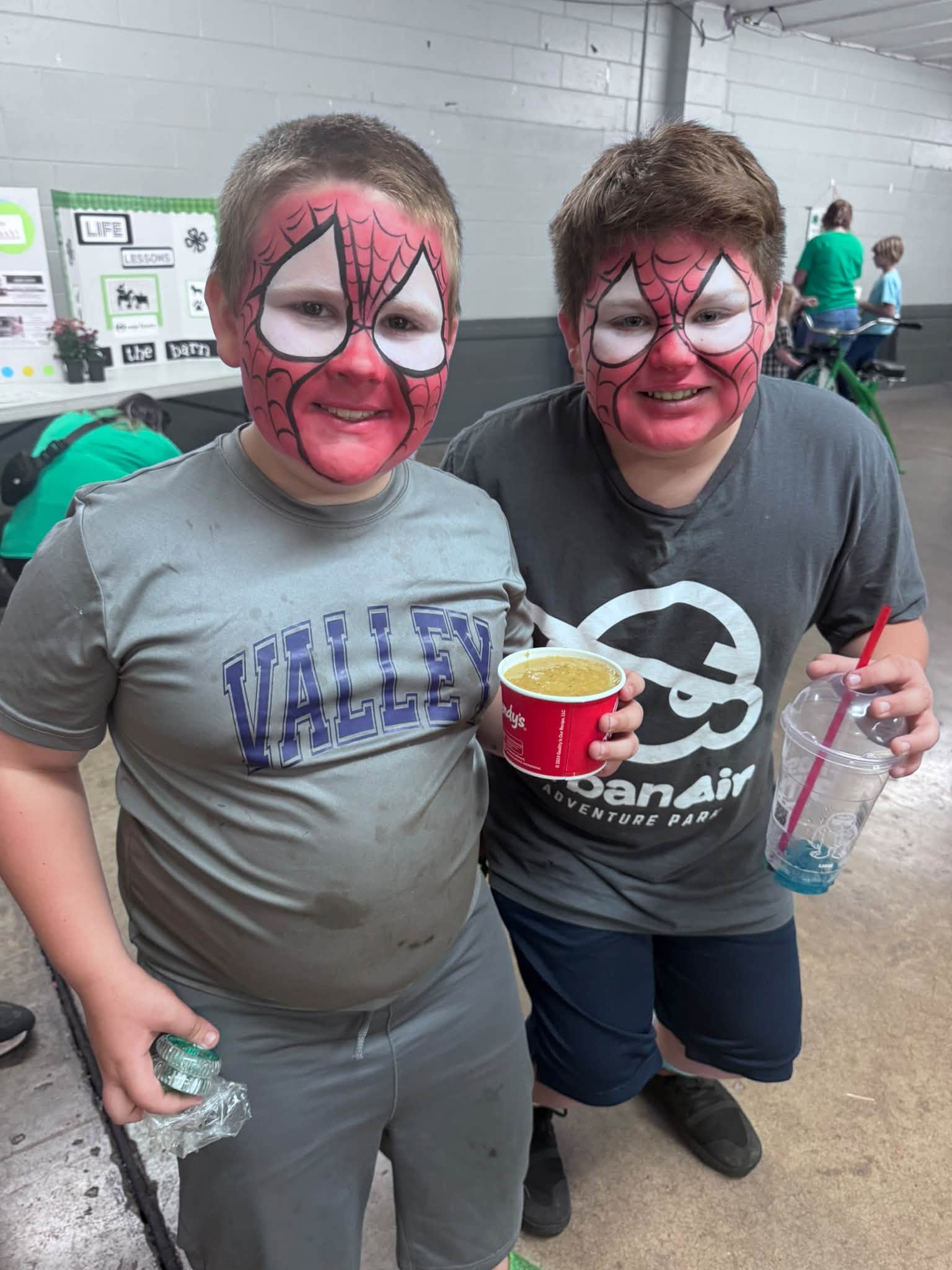 Two 4-H members with face paintings smiling together