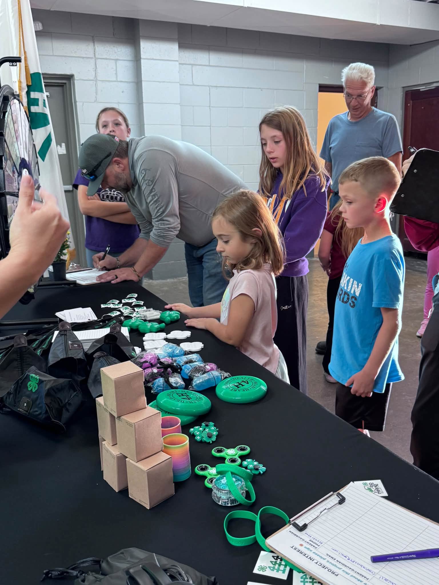 4-H families gathered at a sign in table at the 4-H kickoff event.