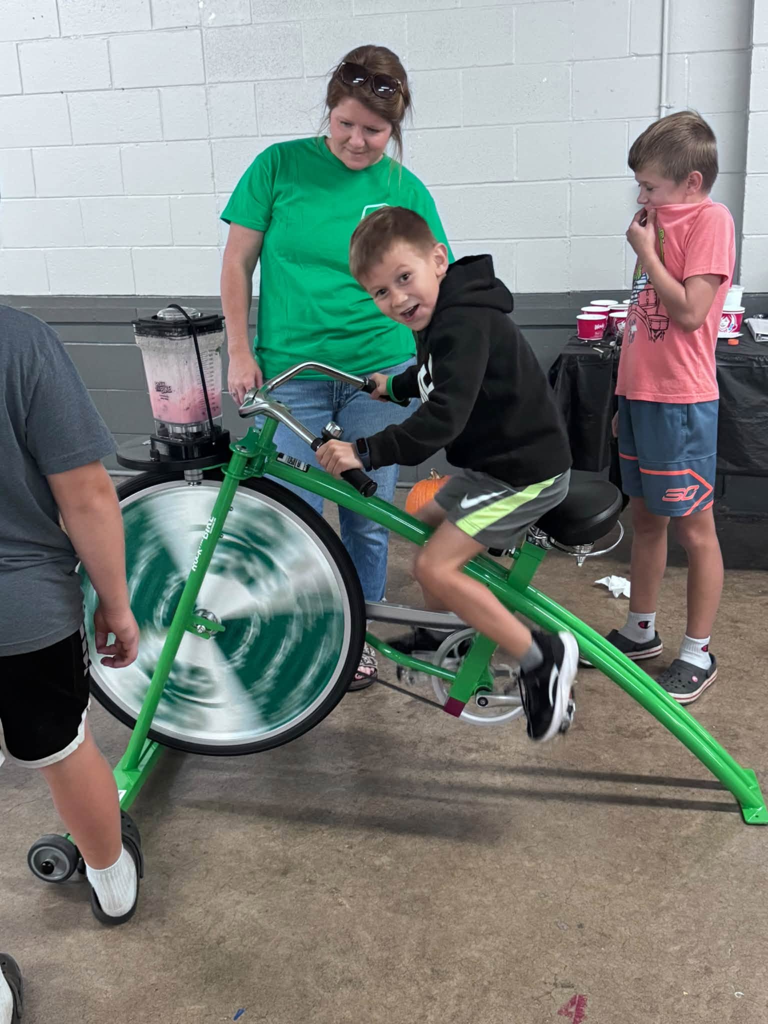 A 4-H member riding a blender bike, making a smoothie