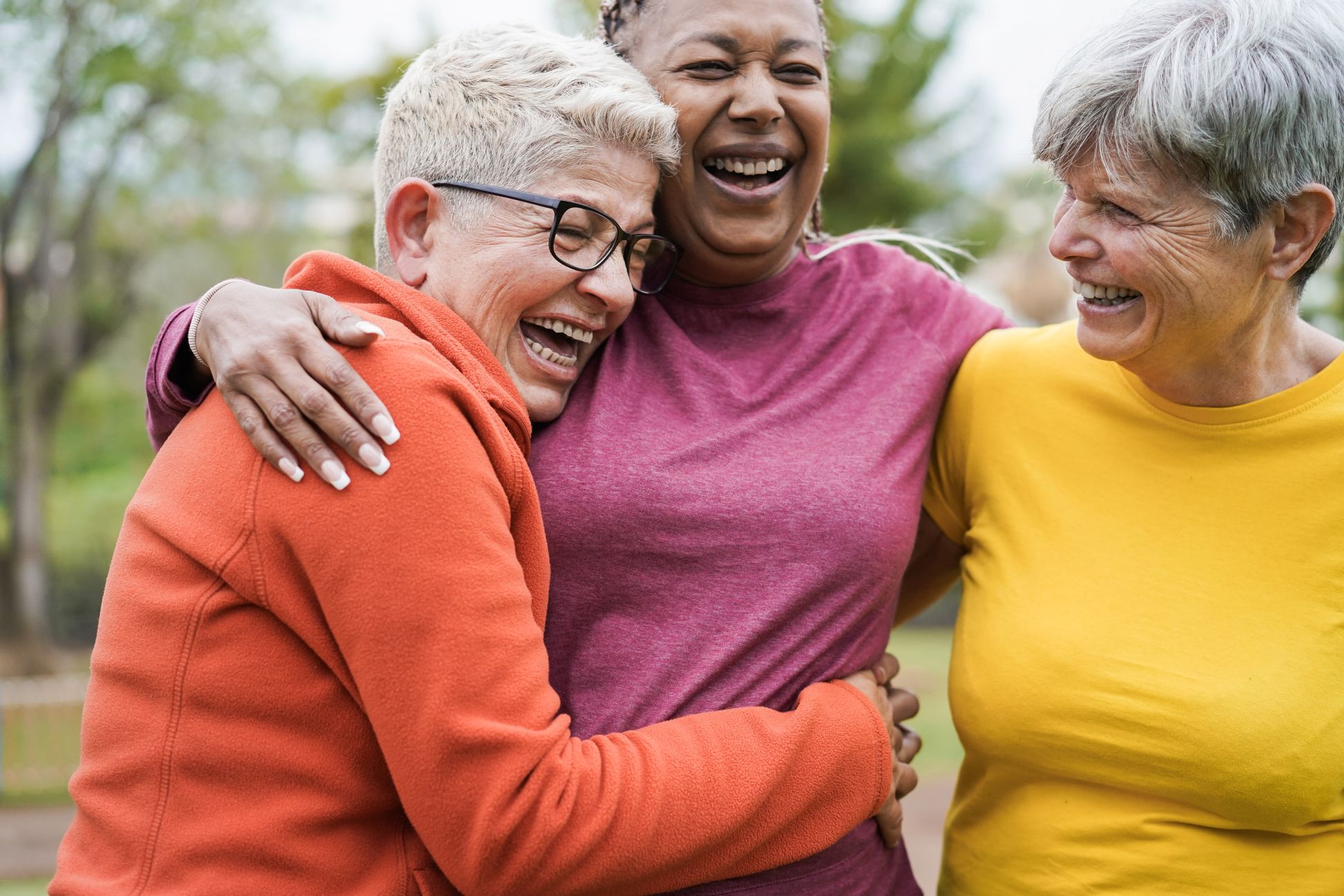 Group of elderly women with their arms around each other in a hug