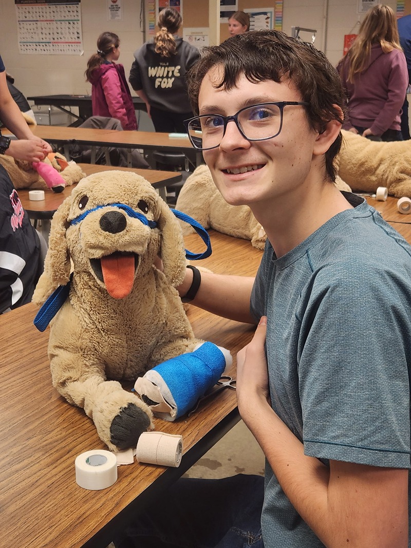 vet demo participant posing with stuffed dog. 