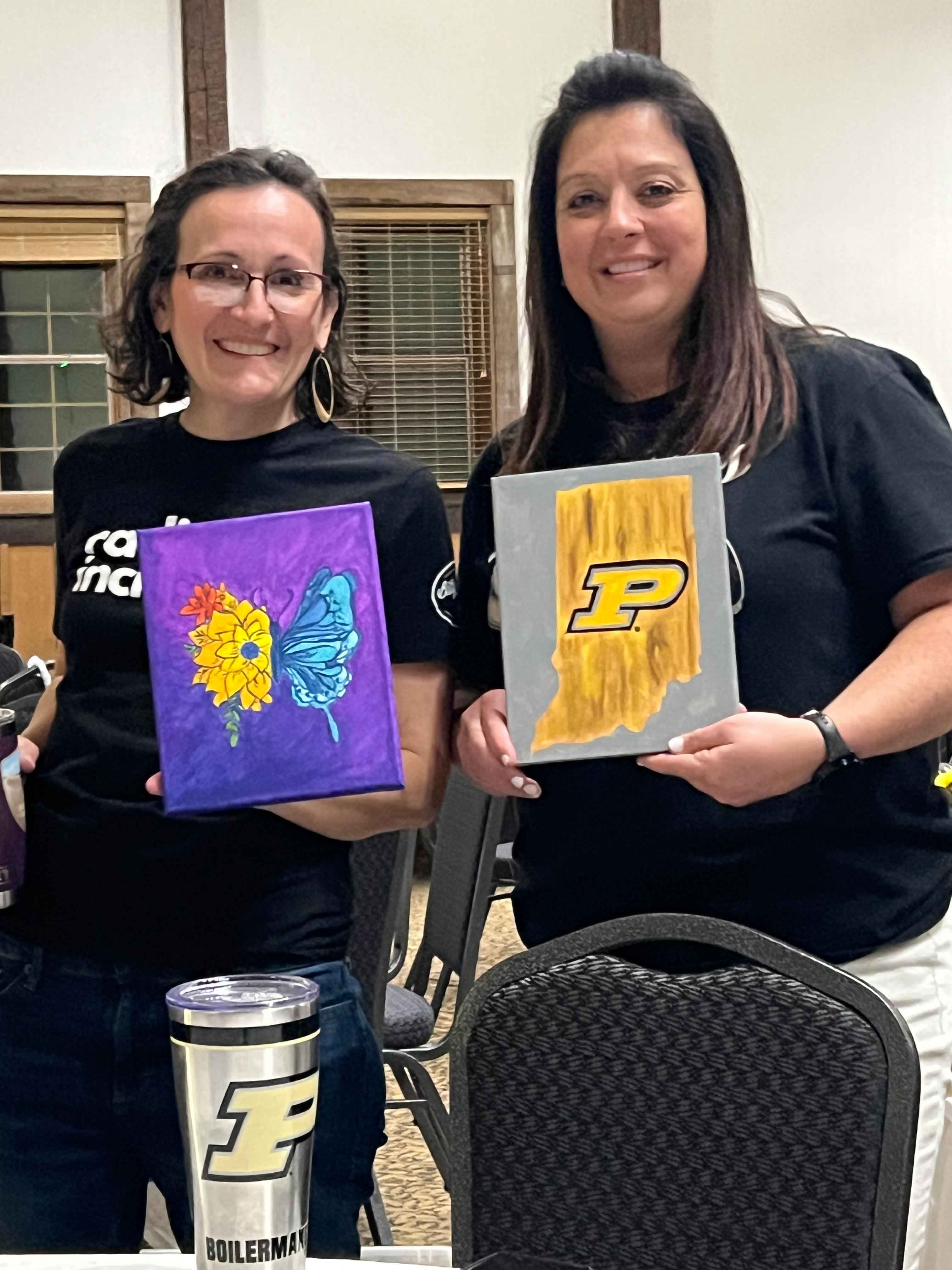 2 women holding paintings