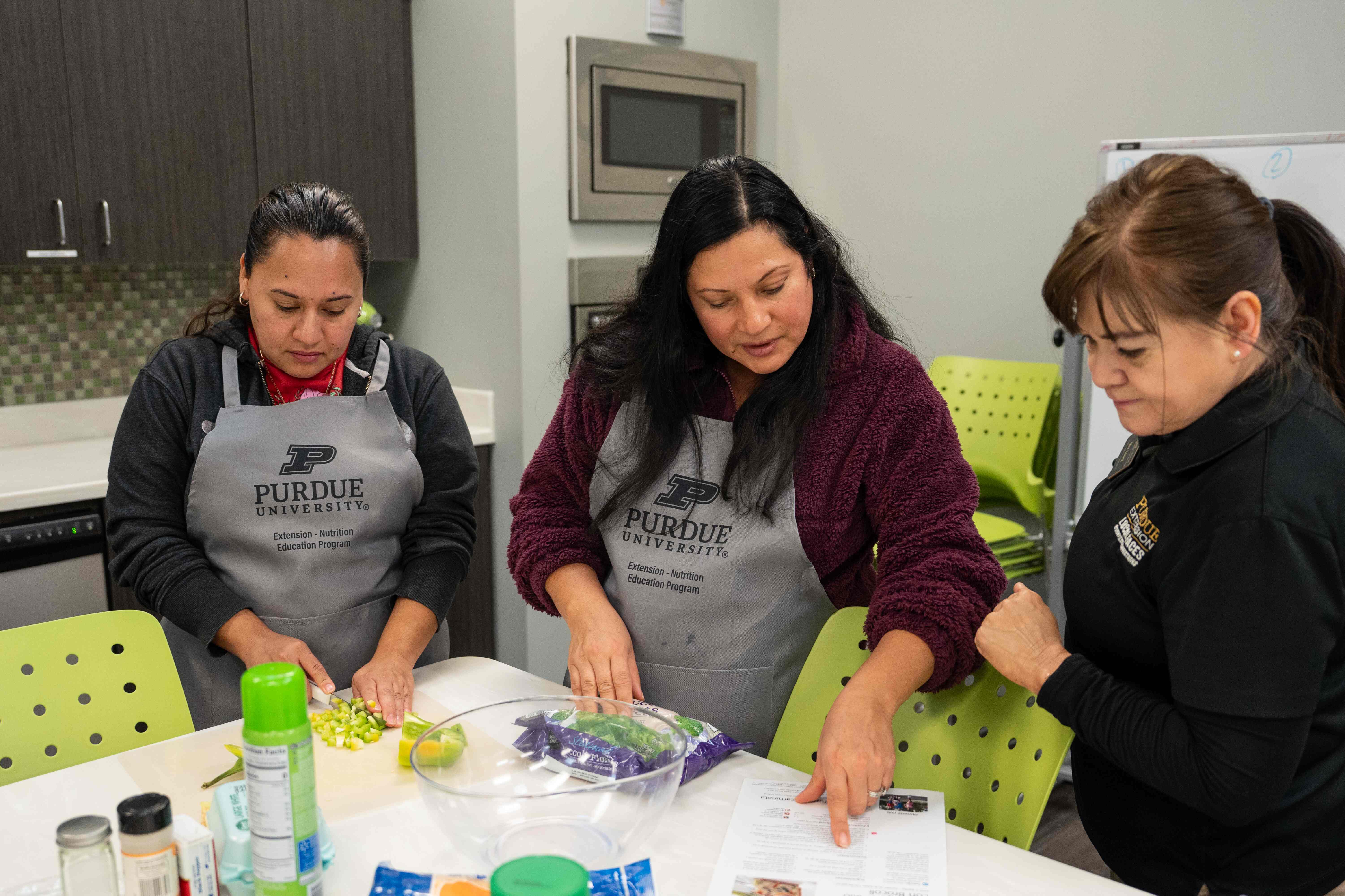 Woman cooking with 2 other women 