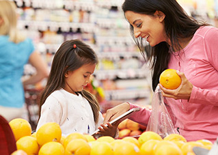 Woman shopping fruit in the supermarket with her child