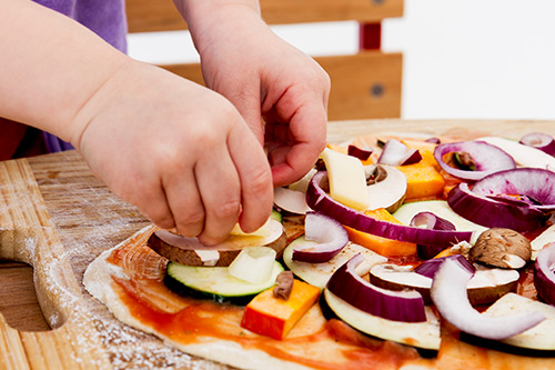 Kid making a pizza