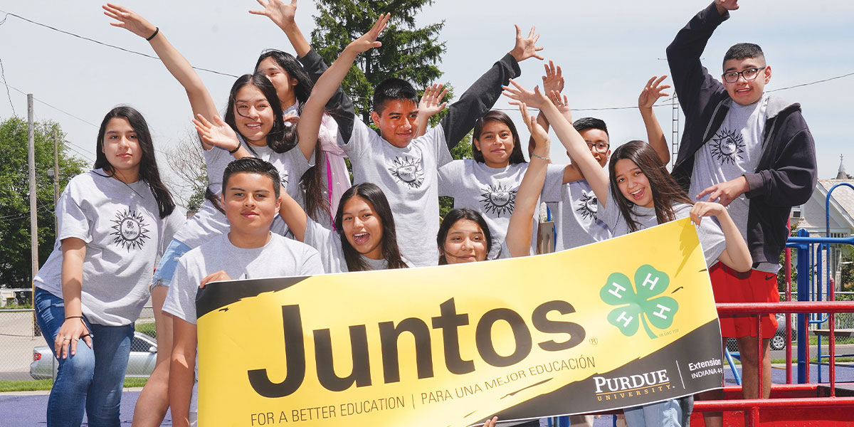 Achievers 4-H Club, the first specialized club for academic success in Indiana. Youth participants pose in front of Purdue Extension Juntos 4-H banner.
