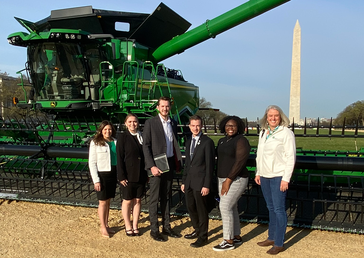 Six people stand in front of combine in the National Mall, Washington D.C.