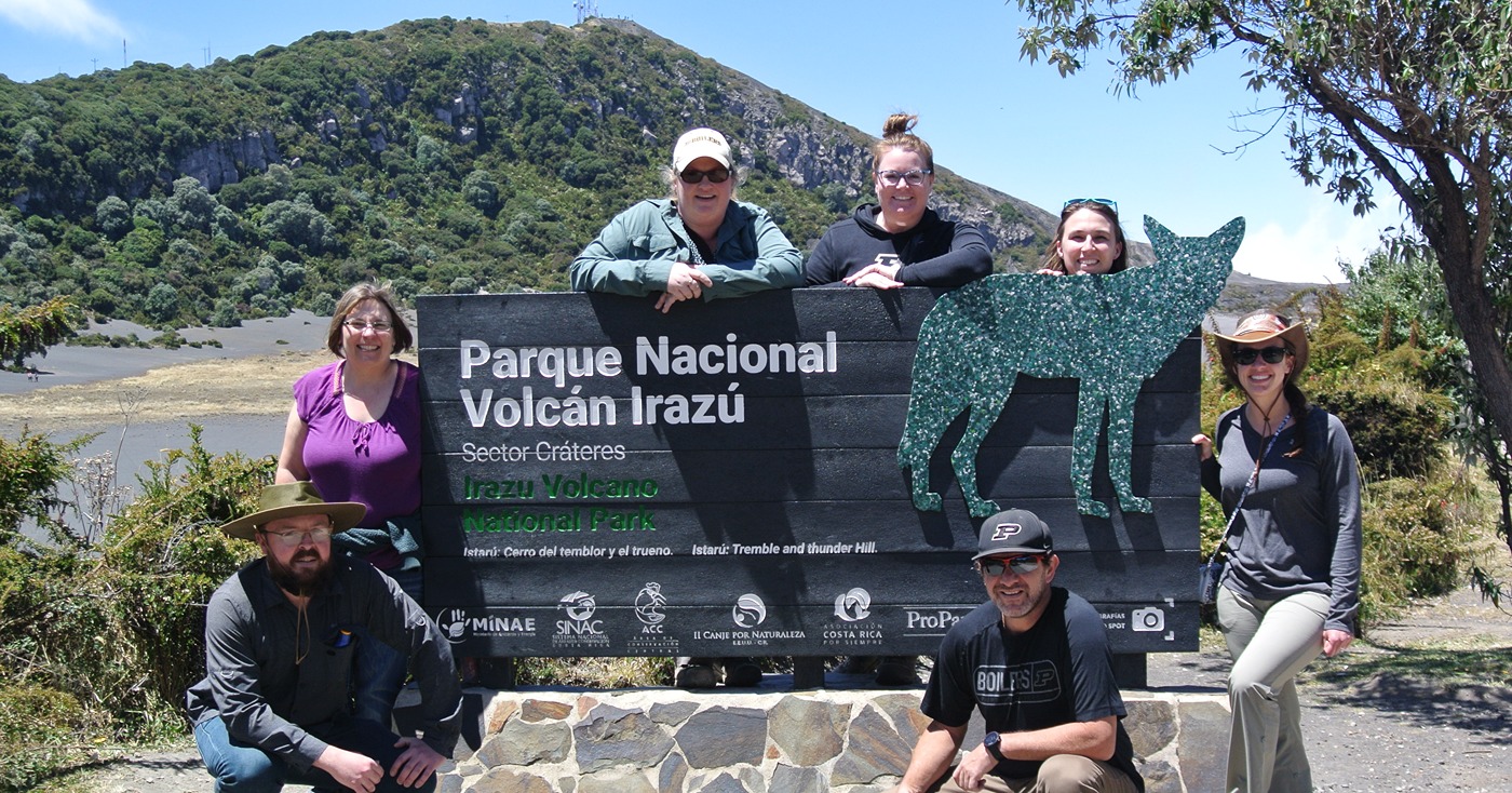 Group of Purdue Extension agriculture and natural resources educators around Parque Nacional Volcan Irazu sign in Costa Rica.