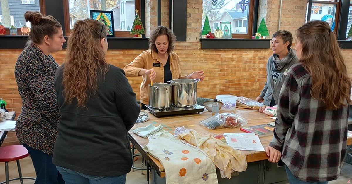 A woman demonstrates how to dye wool