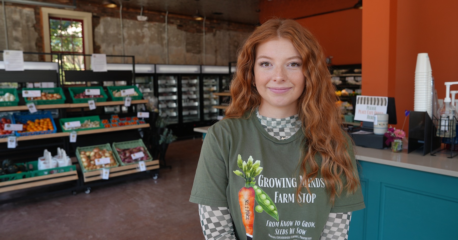 Lilly Cox smiling in front of a checkout counter