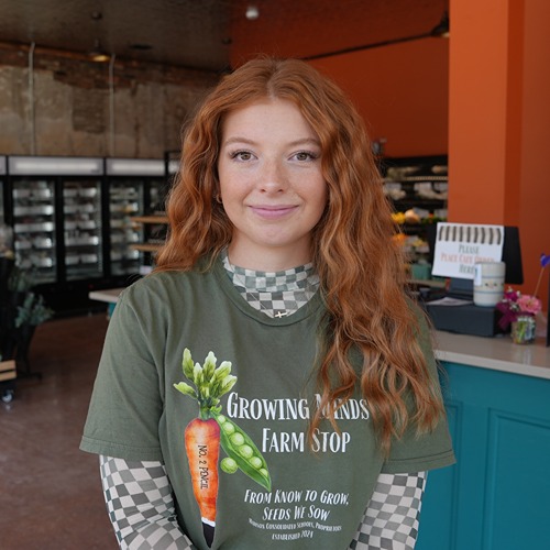 Lilly Cox smiling in front of a checkout counter