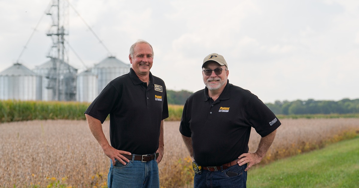 Purdue Extension educators, Brad Kohlhagen and Jeff Burbrink stand in front of a grain bin.