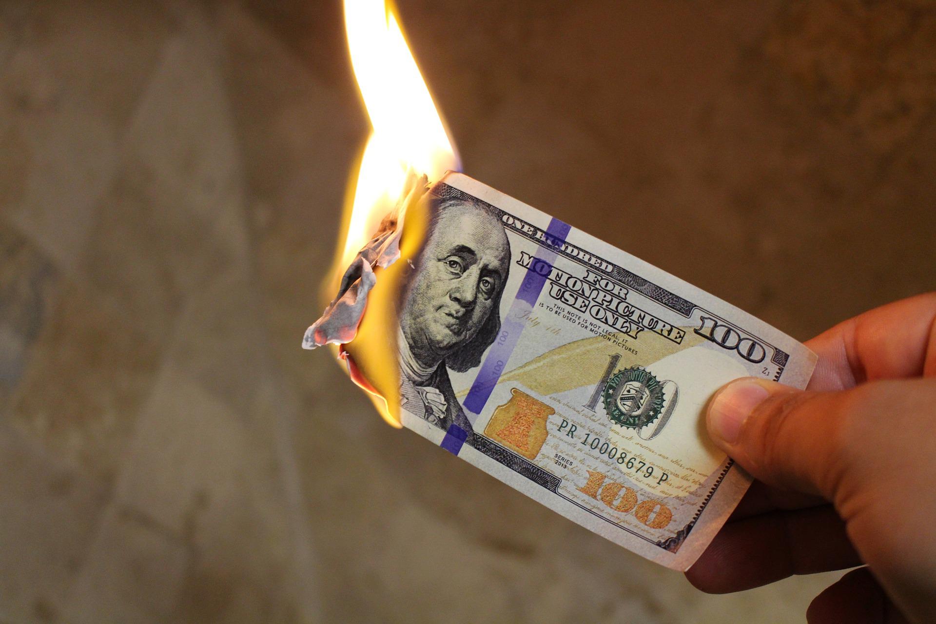 one hundred dollar bill on fire
