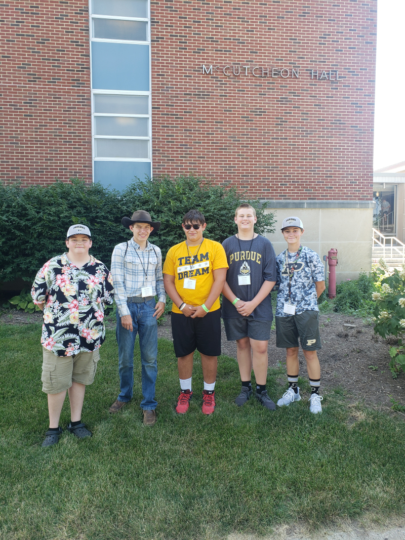 Image of five 4hers standing in front of a brick building called McCutcheon Hall