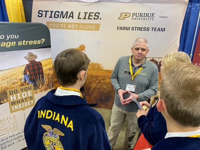 Adam Tyler, Farm Stress team member talking with National FFA Members in the farm stress team booth