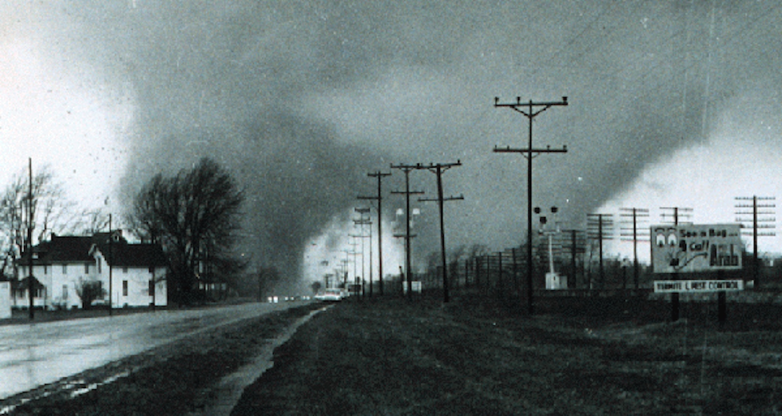 Image of a tornado pasing a town on a dark day