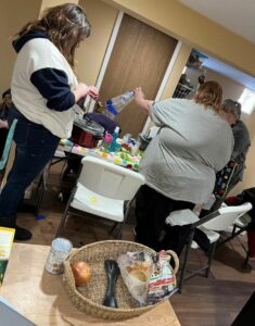 Three of Nutrition Education Program Advisor Marla White's participants work together to prepare a meal.