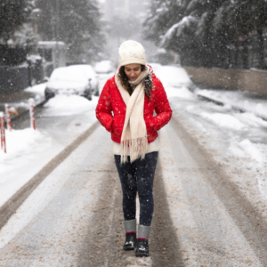 woman walking towards us on a road in the snow