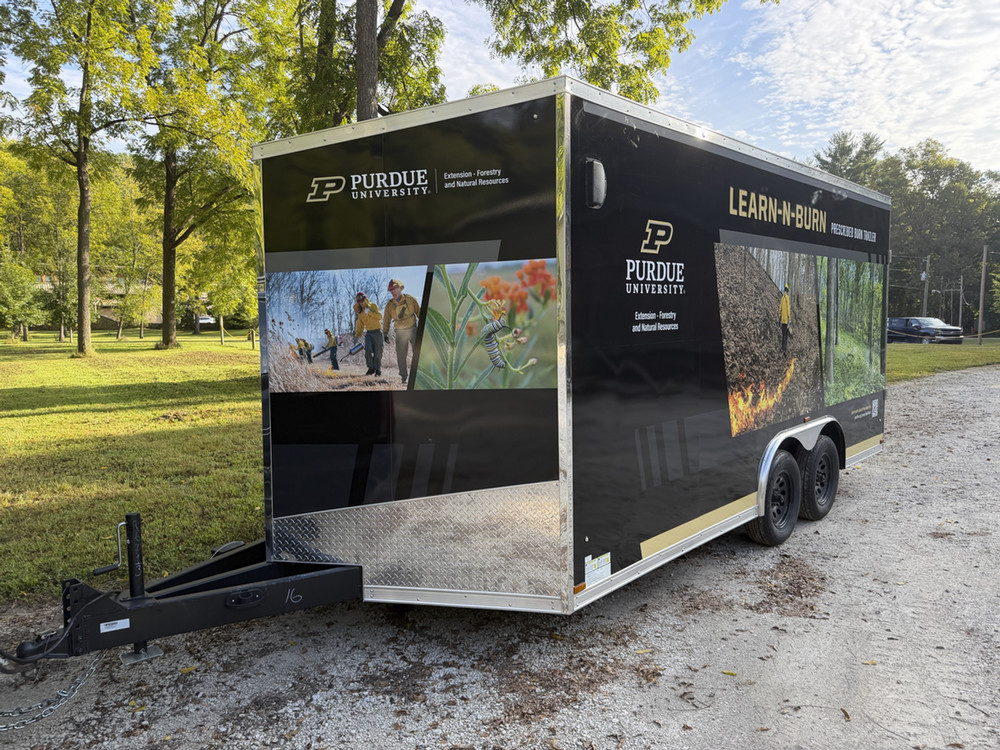 Enclosed trailer wrapped with "Learn-N-Burn" text and images