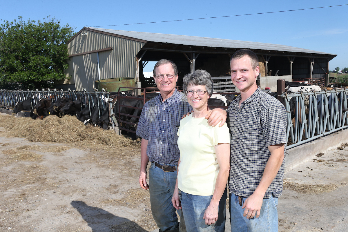 parents and son standing on their family farm