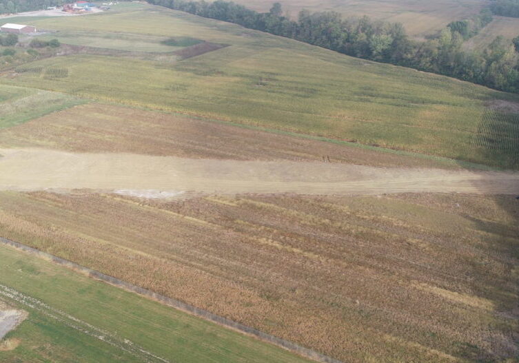 Image of a field showing signs of damage product of a subsurface concrete drain pipe installation